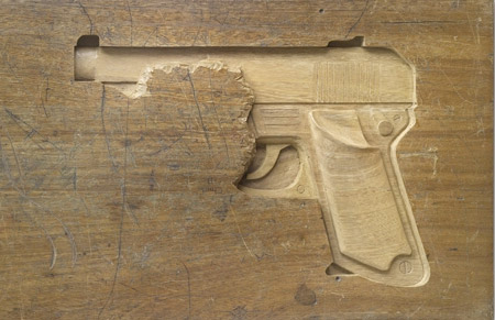 Gun Carved into a Desk