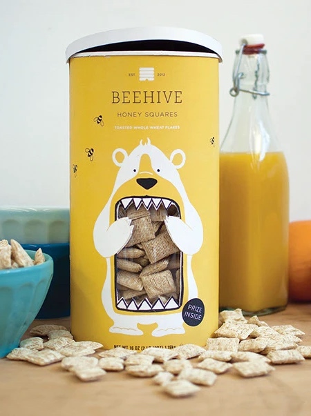 نمای کامل بستهبندی Beehive Honey Squares کنار آبمیوه