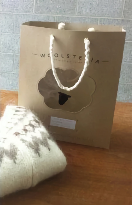 کیف Woolsteria با ژاکت پشمی روی میز